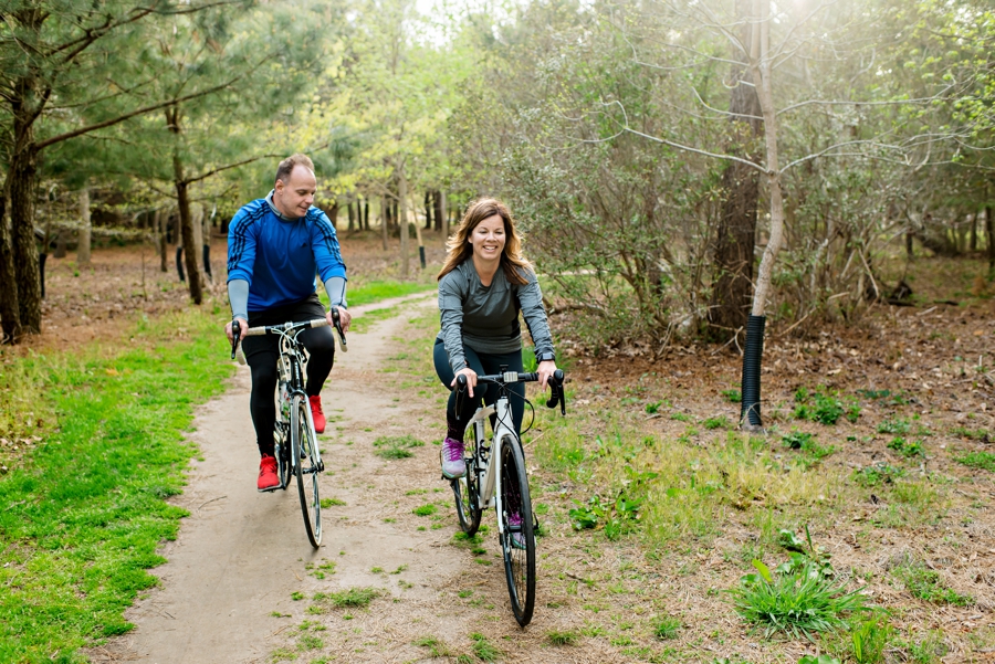A fun couple riding along a bike path in cape may.